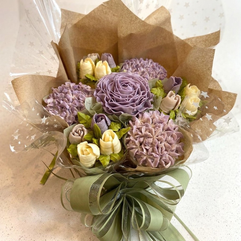Wildflower Meadow cupcake bouquet with lavender and cream buttercream flowers in kraft paper with a sage ribbon bow